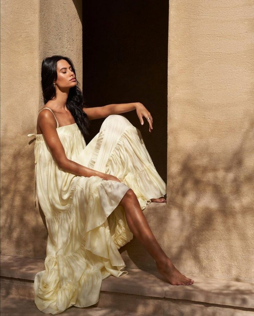 Femme portant une robe jaune pastel longue et fluide 