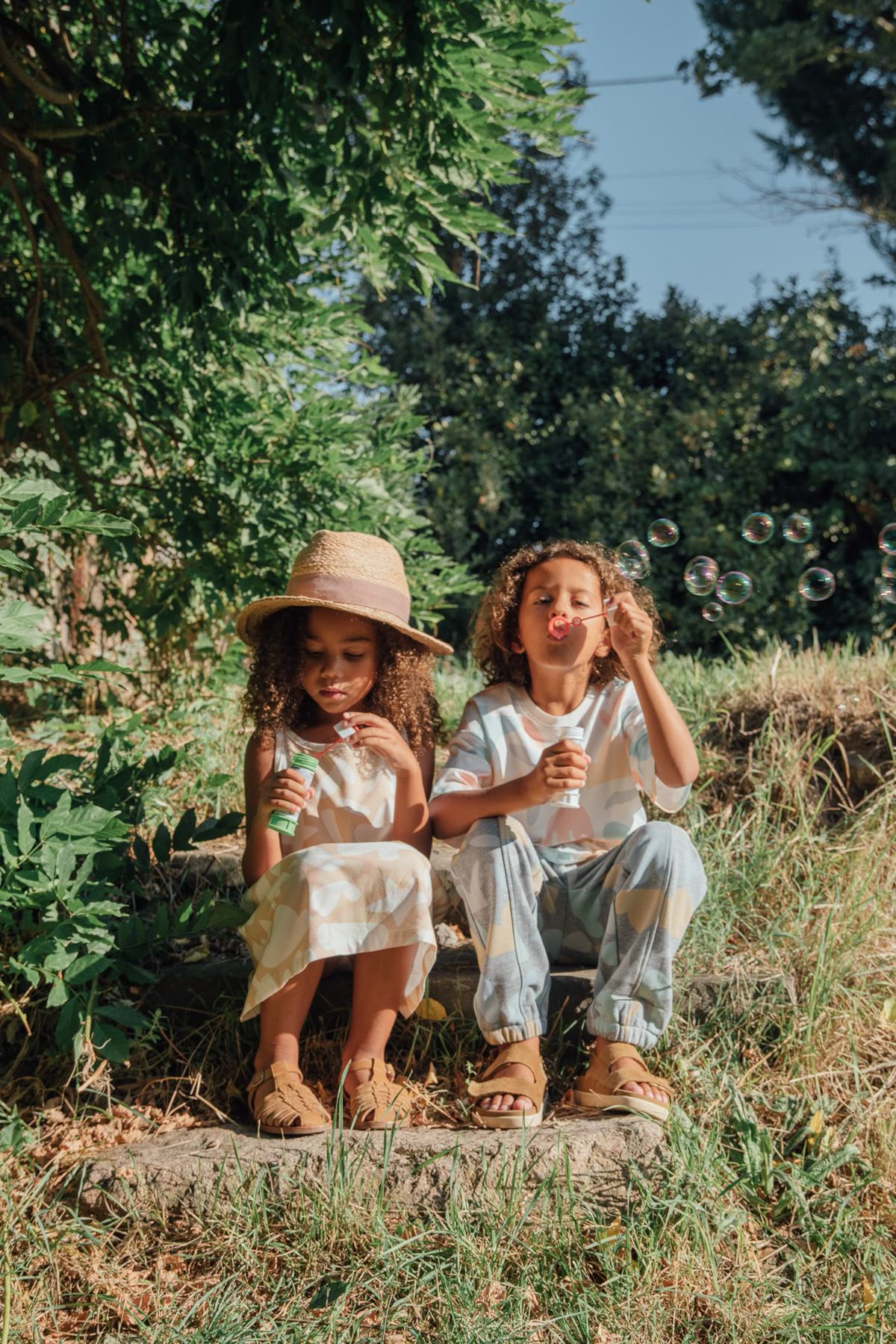 Enfants faisant des bulles assis en forêt 